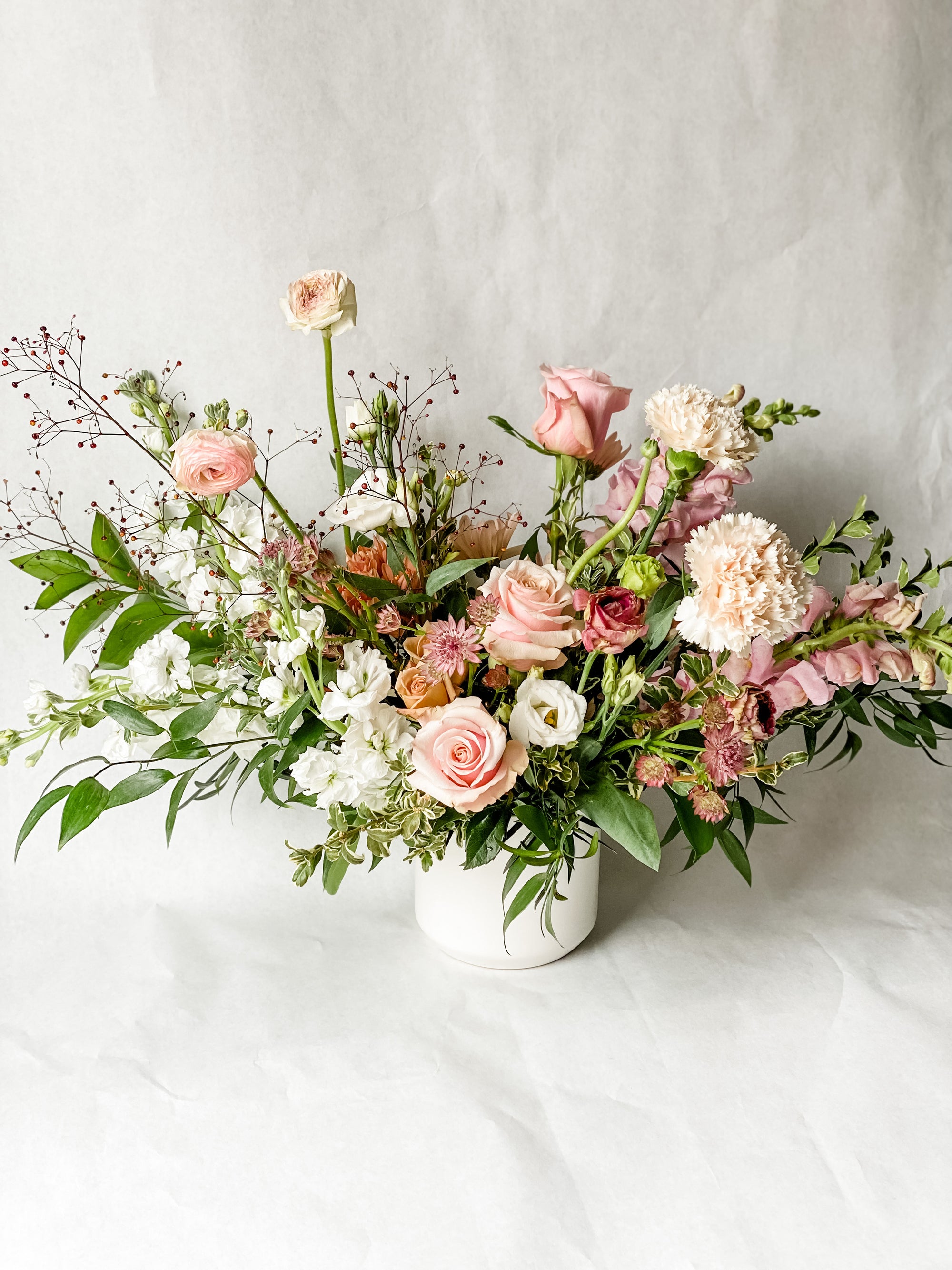arrangement of Pink and white flowers in a white Vase 