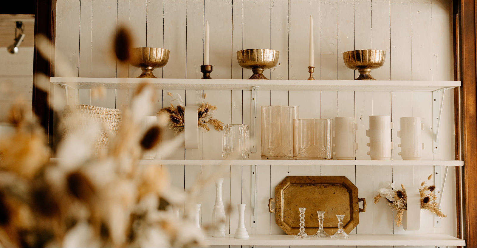 Shelving unit with decorative items against a white paneled wall