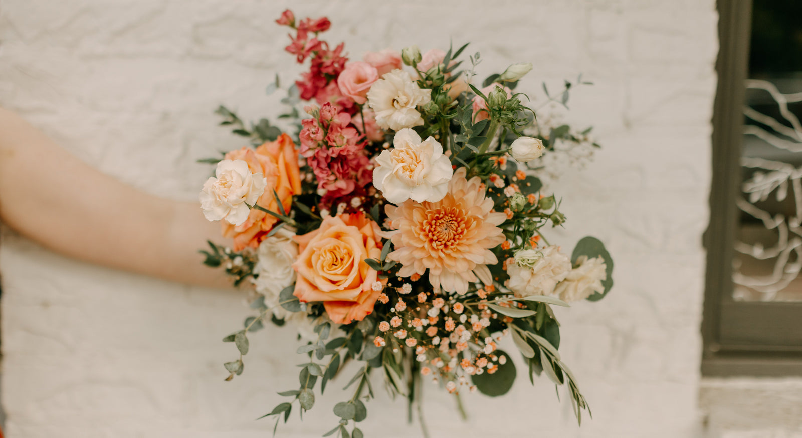 Bouquet of flowers held by a person against a neutral background